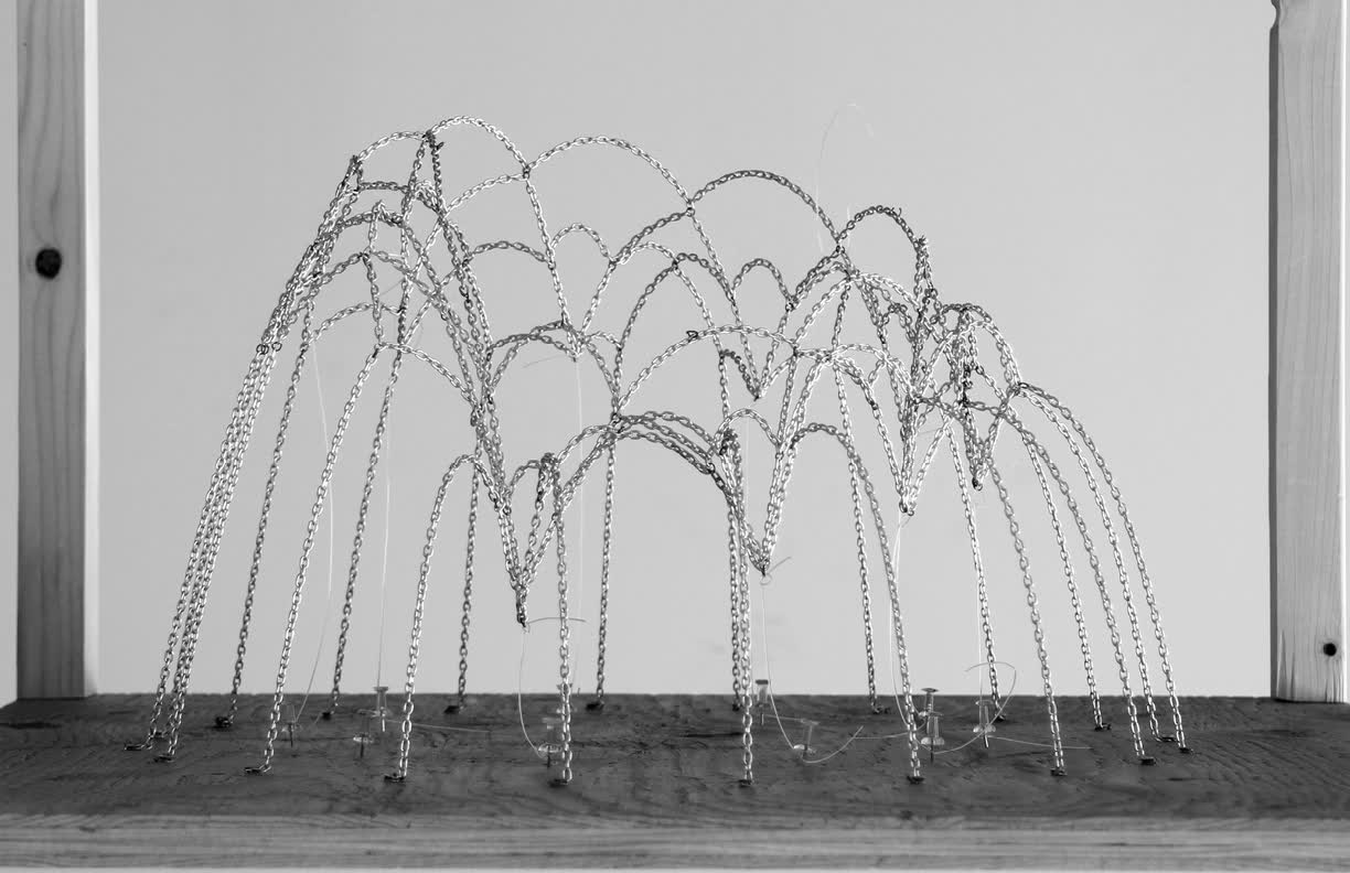 Black-and-white simulation of many thin chains hanging in arches from a flat base, forming a cluster of catenary vaults